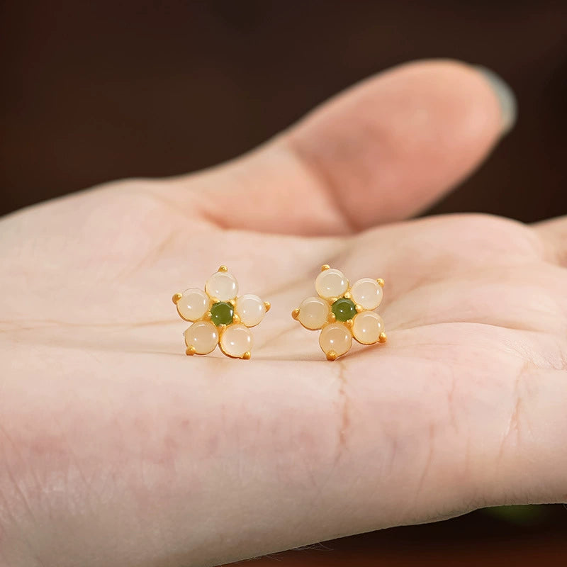 Petite Hetian jade flower earrings with Biyu jade center shown in hand for size reference.