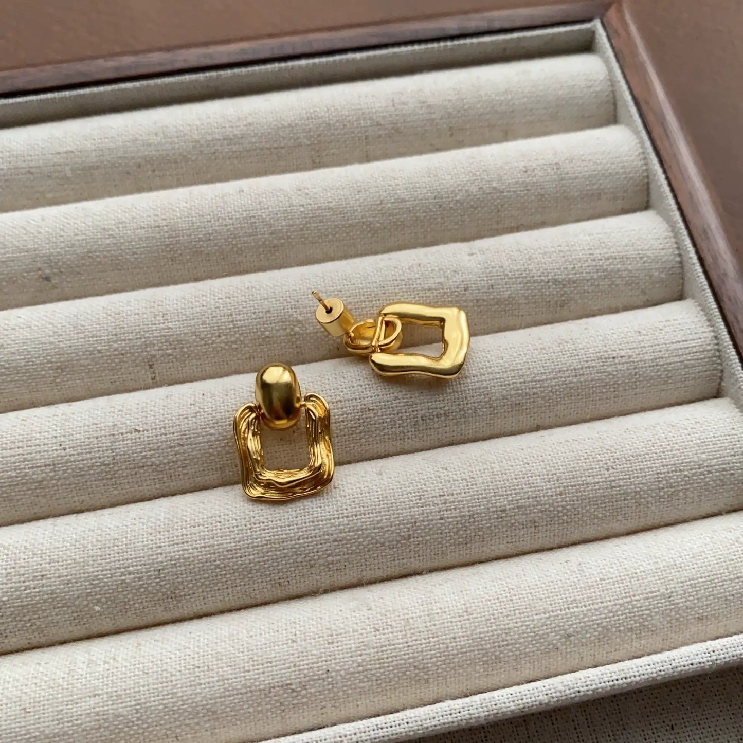 Back view of gold geometric square stud earrings showing post and fastening