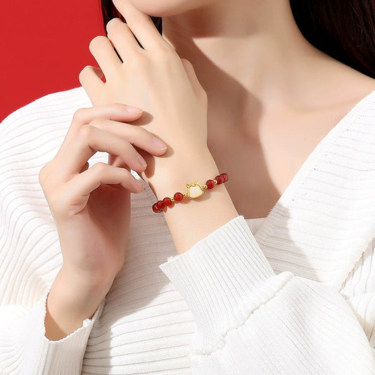 Red agate bracelet worn on wrist with white knit outfit for everyday styling.