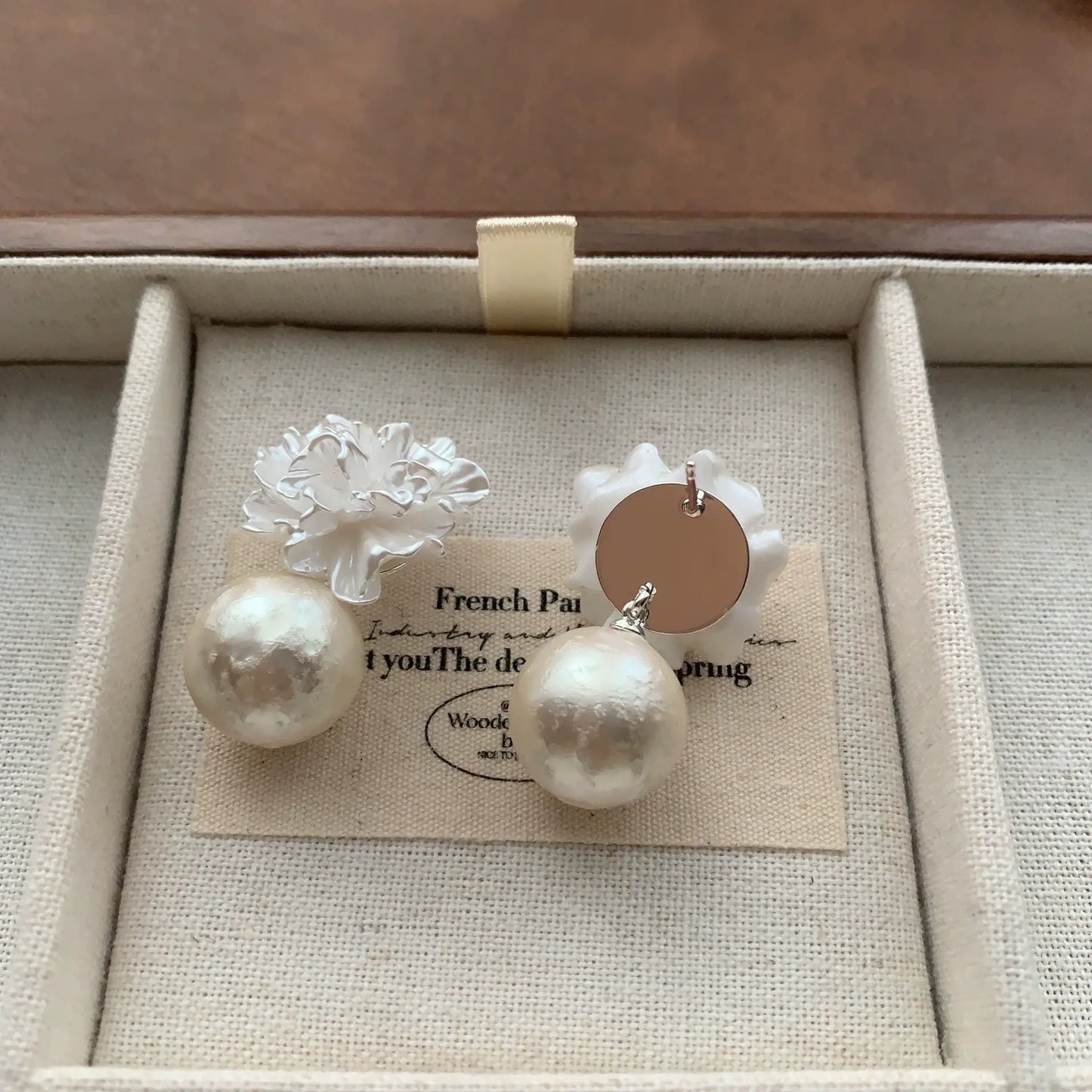 Back view of white resin flower pearl earrings with round stud fastenings.