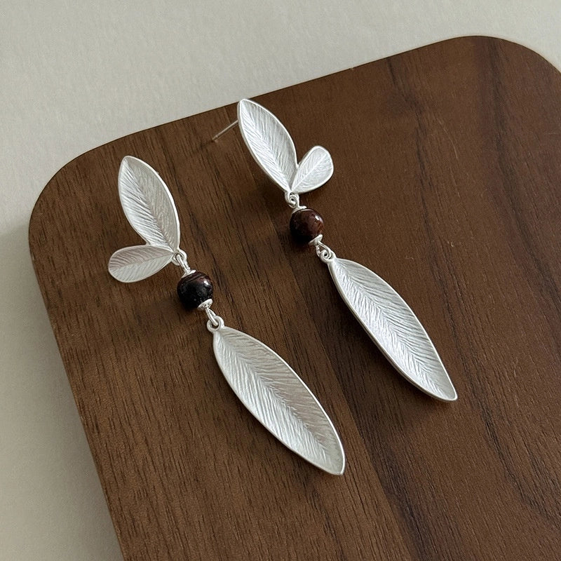 Pair of 925 sterling silver botanical earrings with elongated leaf pendants and dark beads