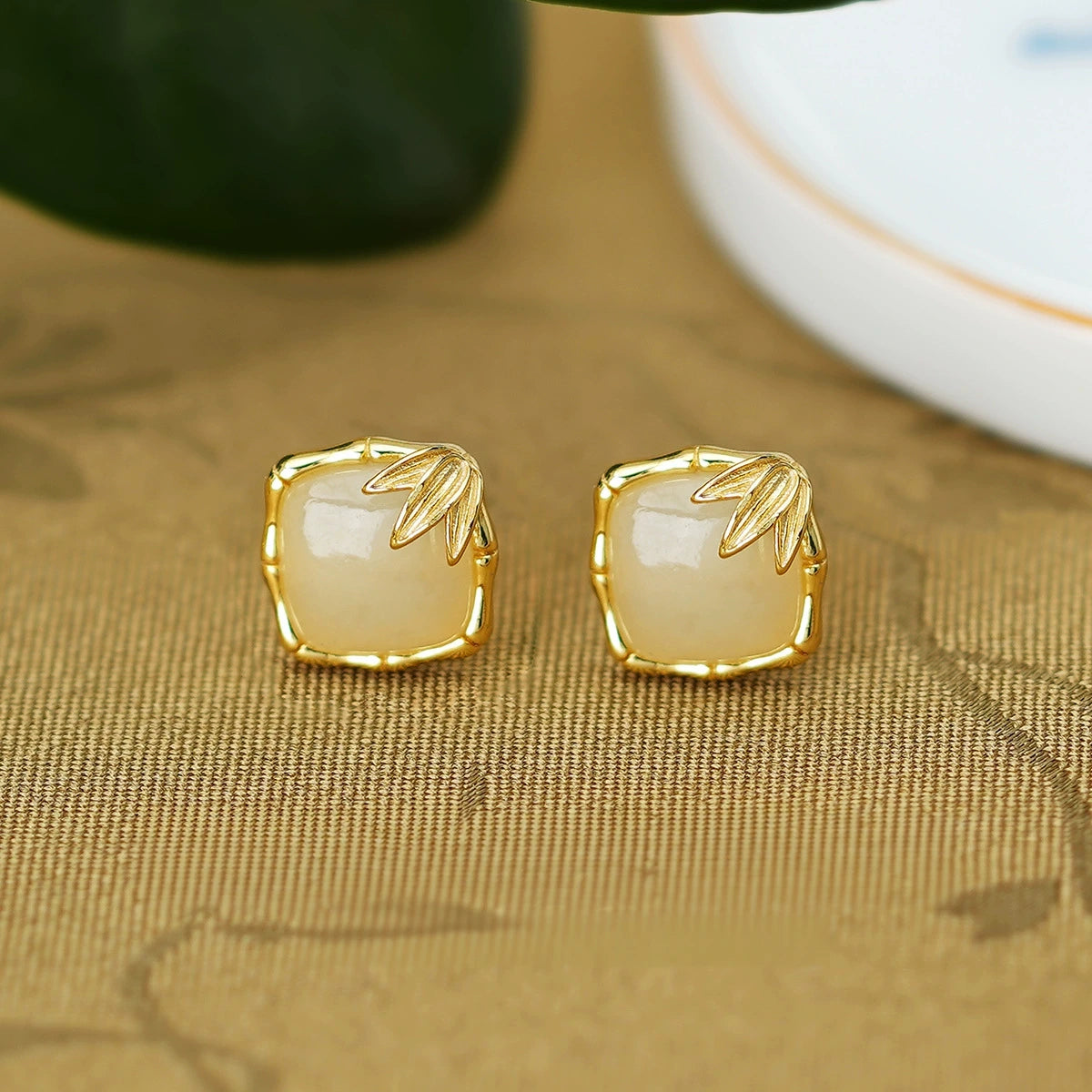 Square Hetian jade earrings with botanical leaf accents and bamboo-style frames