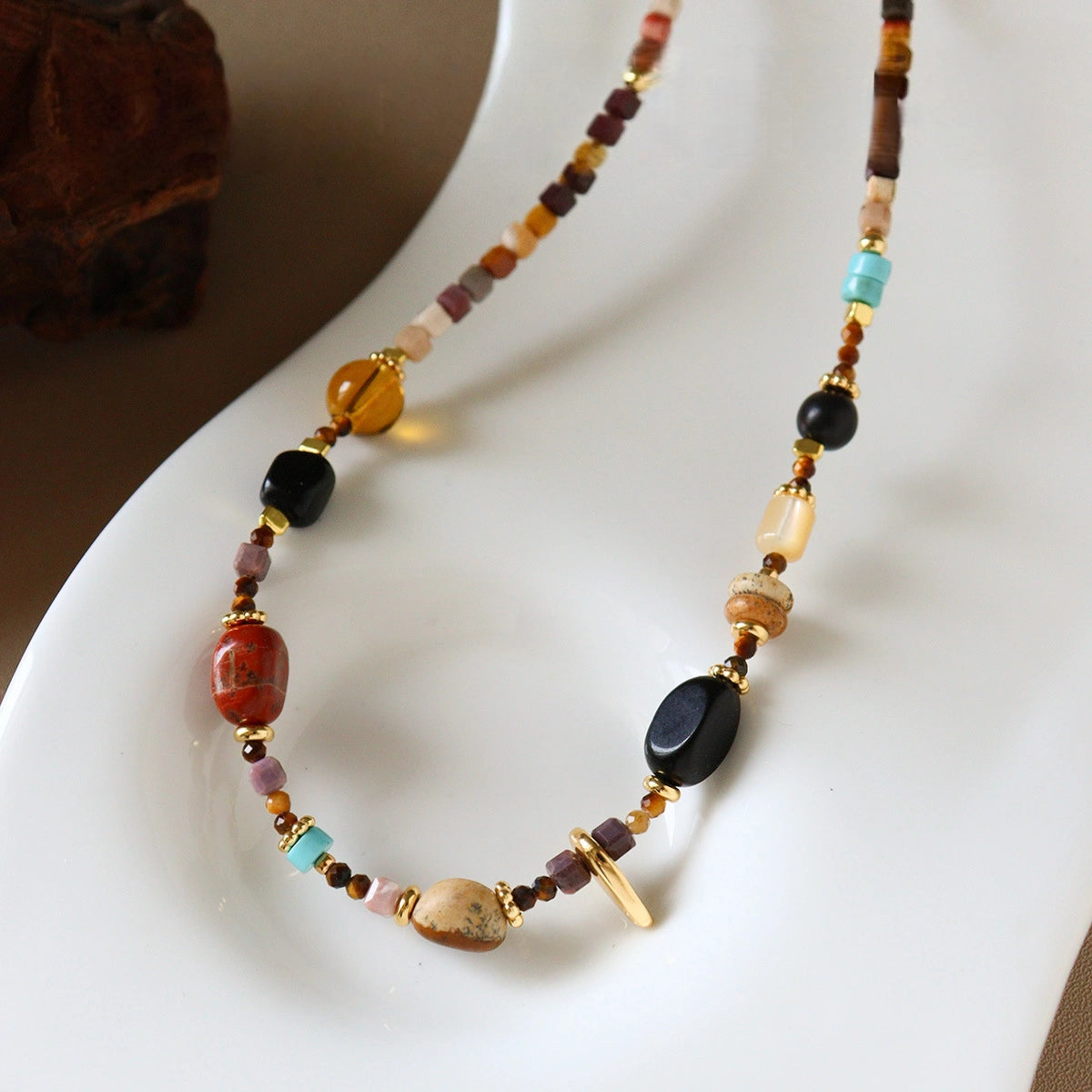 Multicolor stone beaded necklace displayed on white jewelry stand with bohemian style