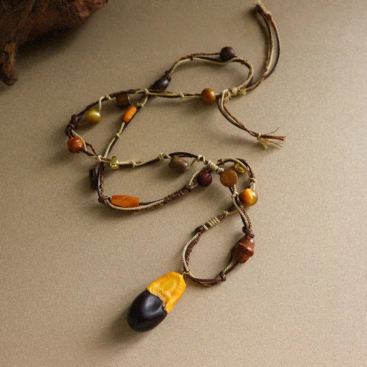 Rustic boho long pendant necklace with tiger eye stone, wood beads, brass details, and braided cord