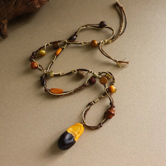 Rustic boho long pendant necklace with tiger eye stone, wood beads, brass details, and braided cord