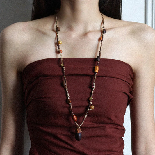 Boho long pendant necklace styled on model with tiger eye stone, wood beads, and rustic ethnic design