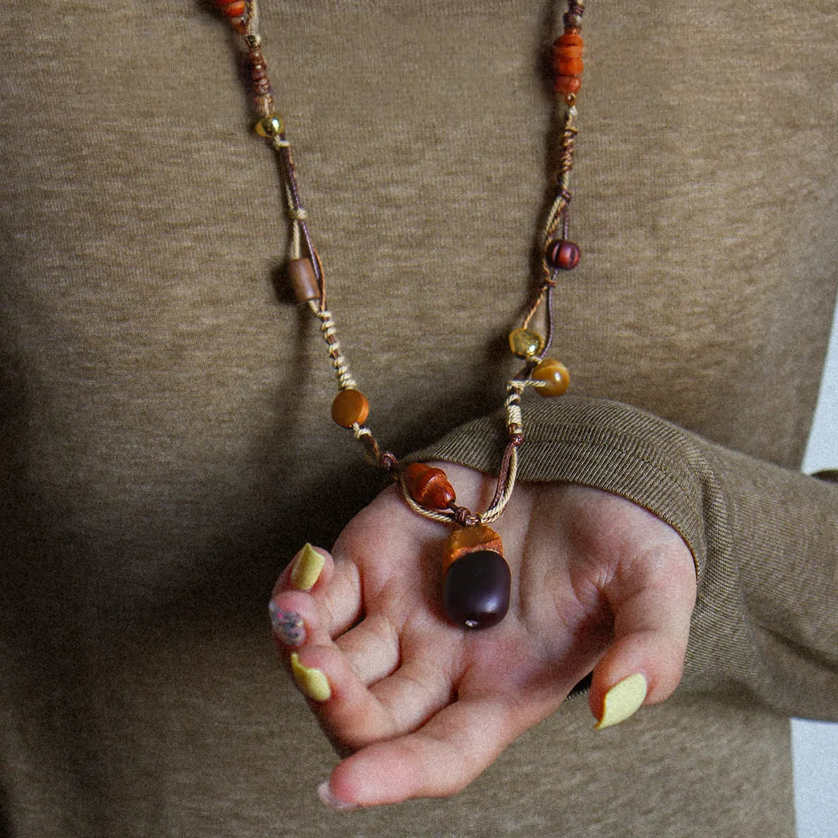 Tiger eye wood pendant necklace worn with sweater, featuring brass beads and vintage boho cord design