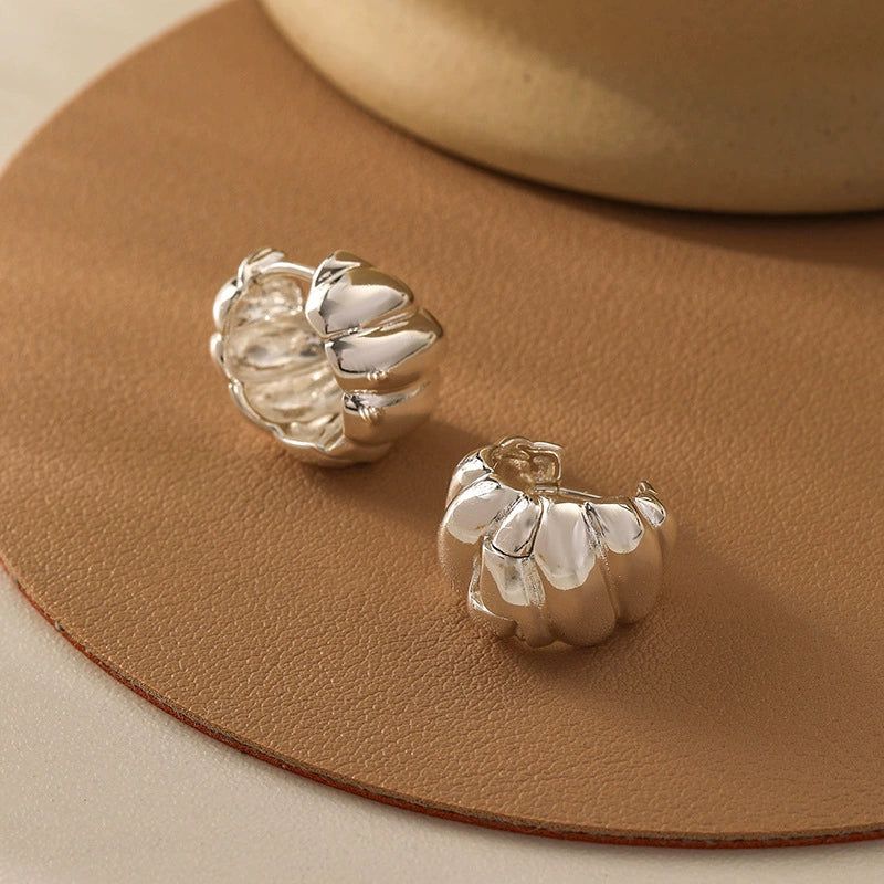 Silver tone croissant hoop earrings with polished chunky curves and modern vintage style