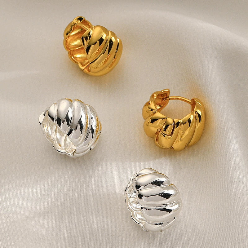 Gold and silver croissant hoop earrings showing twisted dome design and compact shape