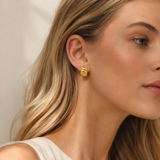 Model wearing gold tone croissant hoop earrings in an elegant everyday look