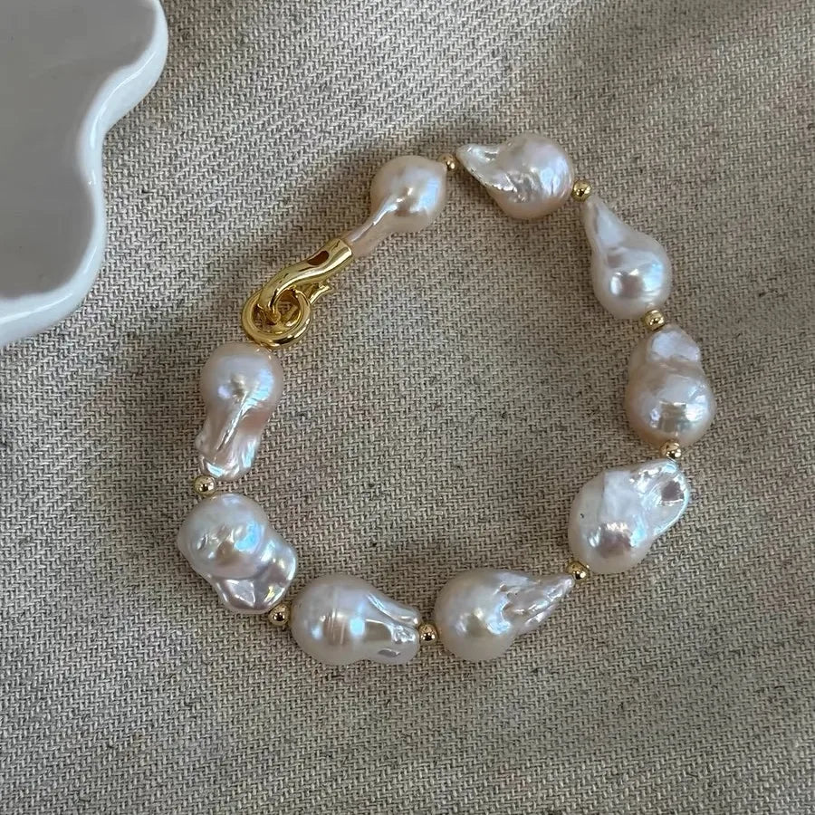 Fishtail baroque pearl statement bracelet with irregular white pearls and a gold-plated clasp