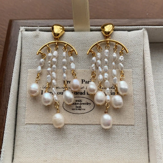 Gold-plated pearl chandelier tassel earrings displayed in a linen jewelry box