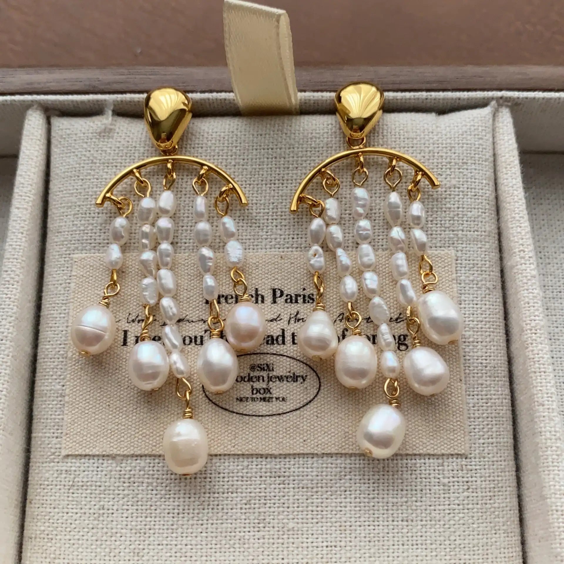 Front view of gold-plated pearl chandelier earrings with cascading irregular pearls