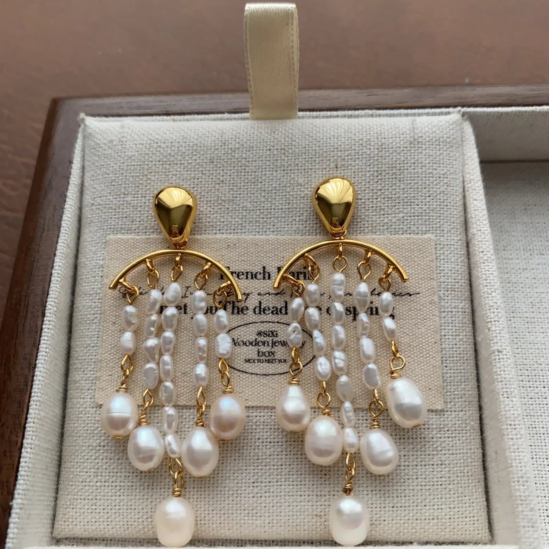 Gold-tone multi-strand pearl tassel earrings with teardrop pearl accents