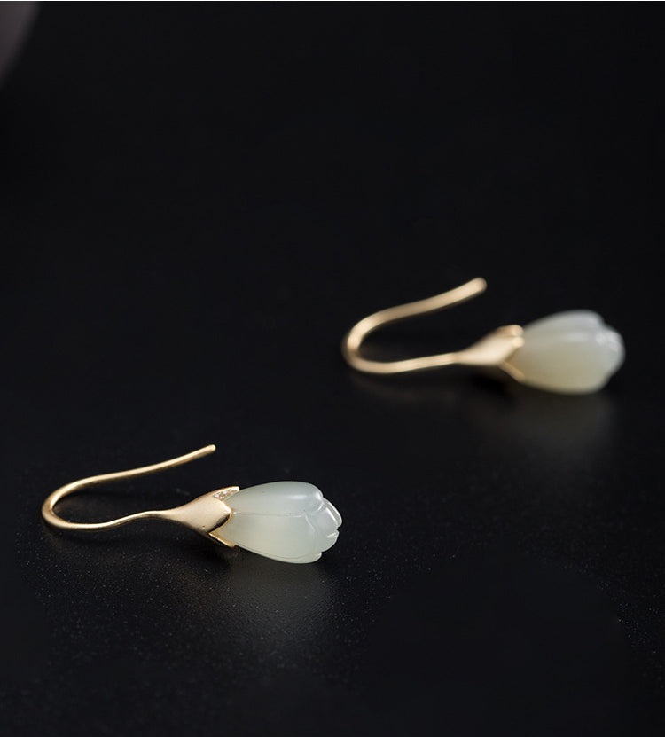Vintage Hetian jade dangle earrings with delicate gold hooks shown in side view.