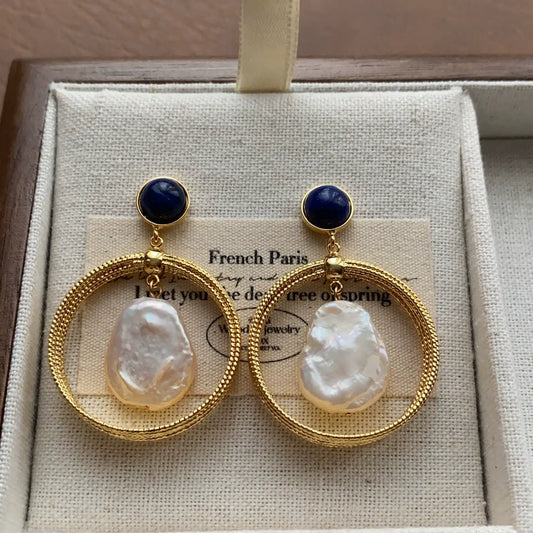 Lapis lazuli baroque pearl hoop earrings displayed on a linen jewelry box