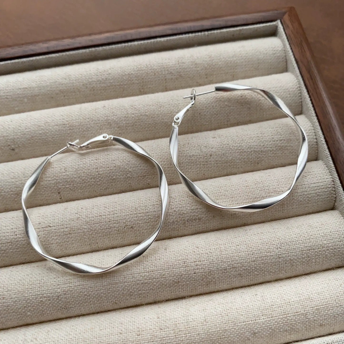 Silver Möbius loop hoop earrings with a sculptural twisted finish