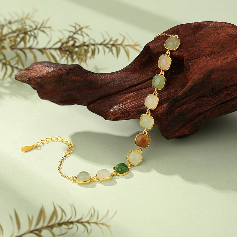 Multi-color Hetian jade S925 chain bracelet on wood with earthy green and amber square jade beads.