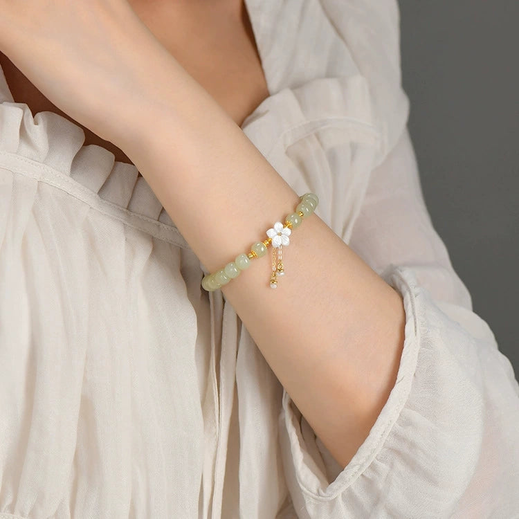 Natural Hetian jade sakura pearl tassel bracelet worn with white blouse.
