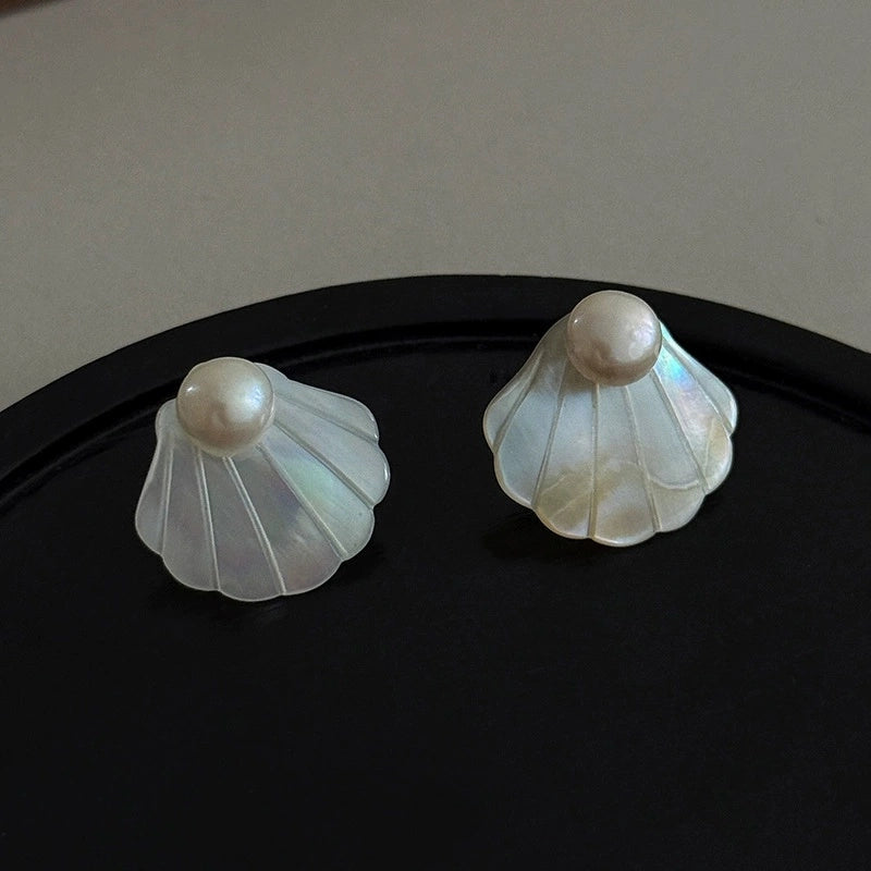 Natural mother-of-pearl seashell stud earrings with iridescent white shell and pearl accents.