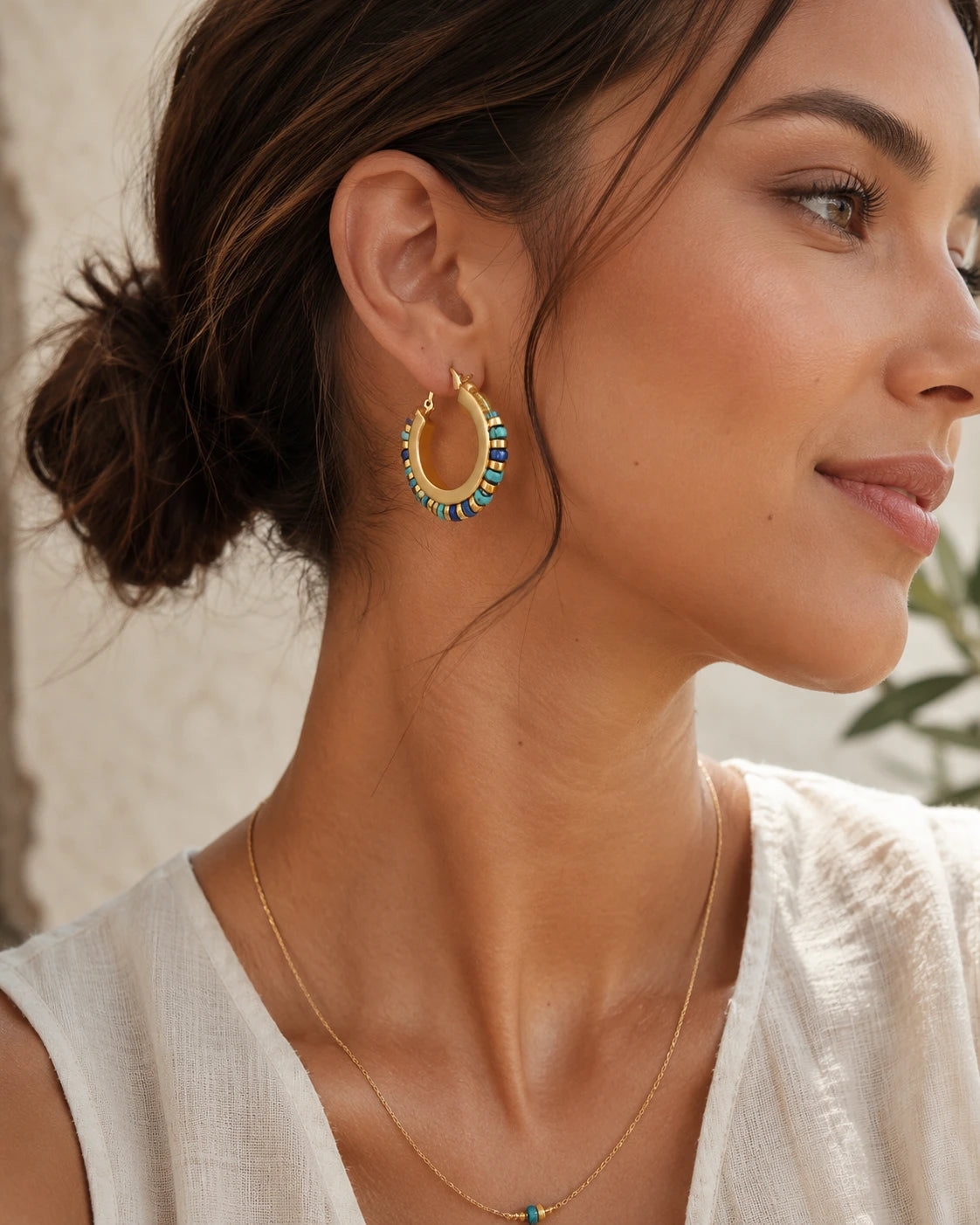 Woman wearing colorful natural stone hoop earrings with elegant bohemian summer style
