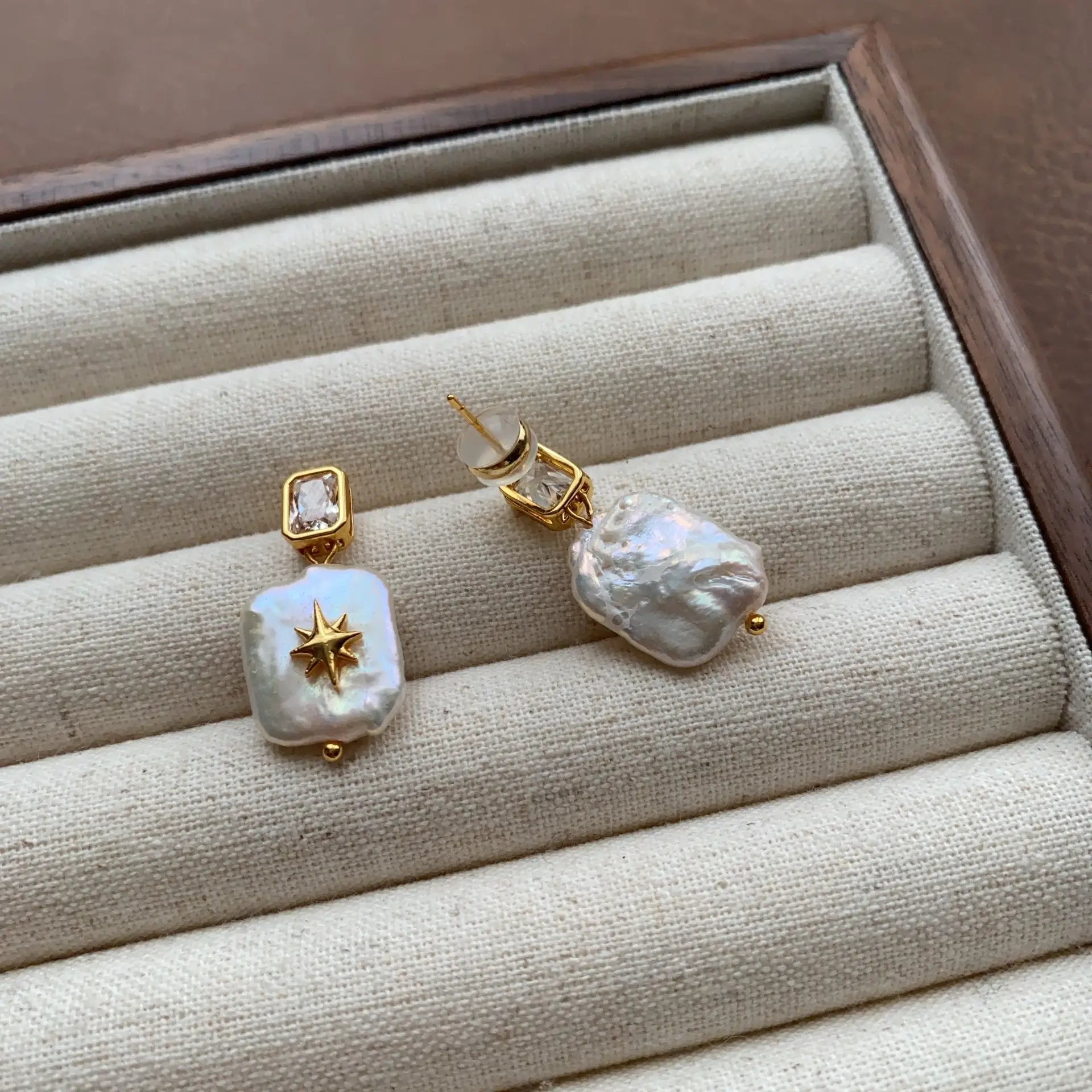 Front and back view of gold-plated baroque pearl dangle earrings with North Star details