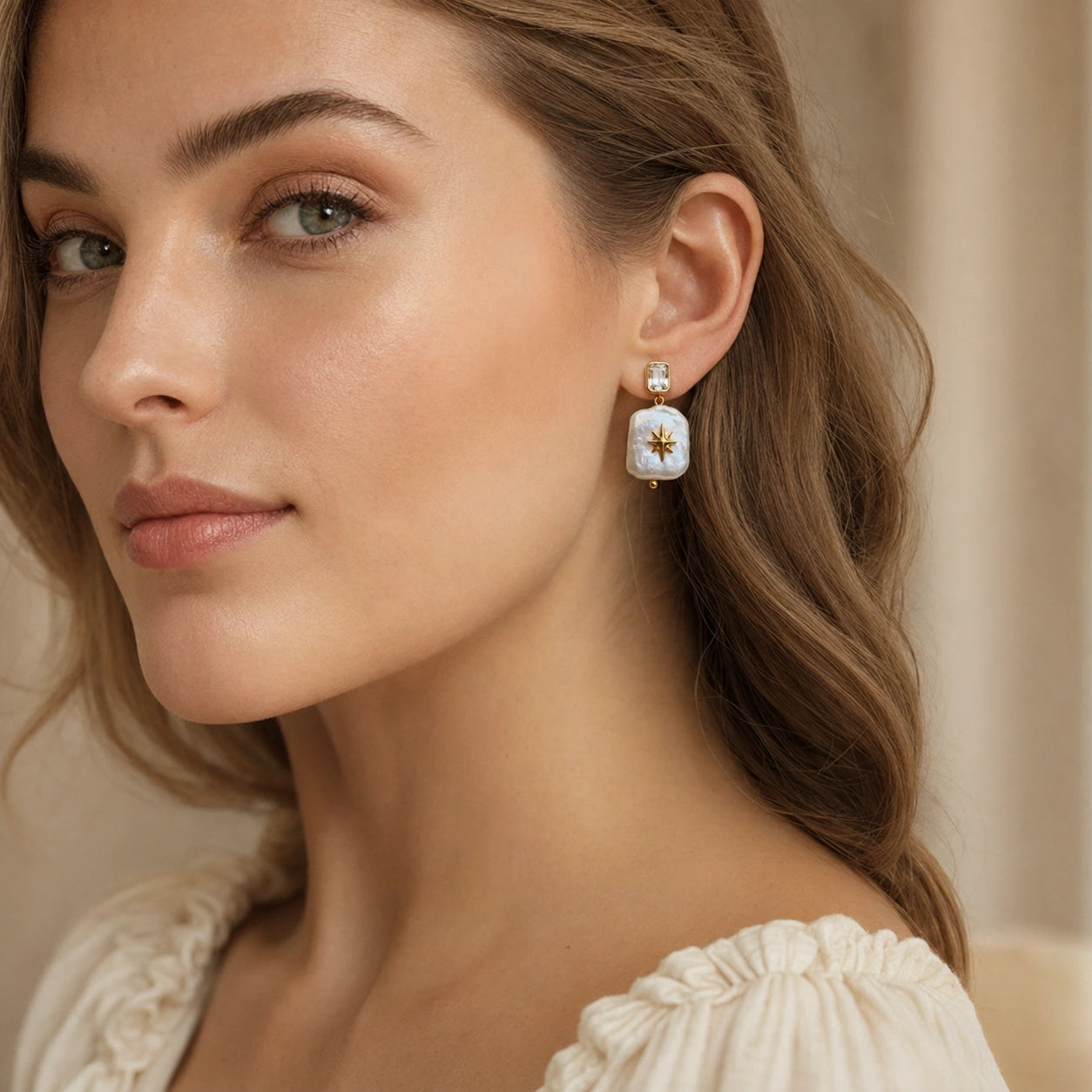 Woman wearing North Star square baroque pearl dangle earring with a crystal stud and gold-plated details