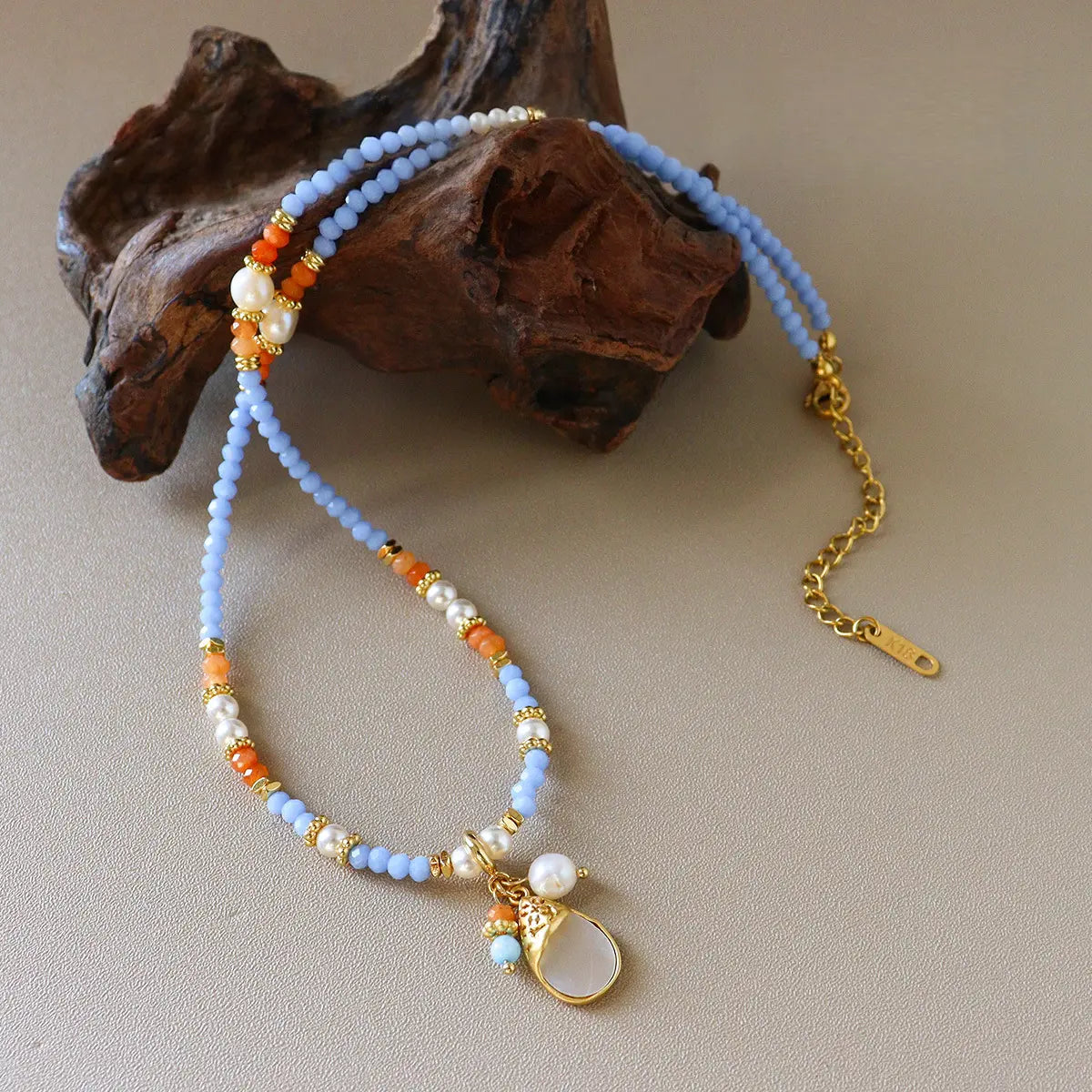 Boho chic pastel blue beaded necklace with shell pendant, glass beads, natural stone, and gold-tone chain