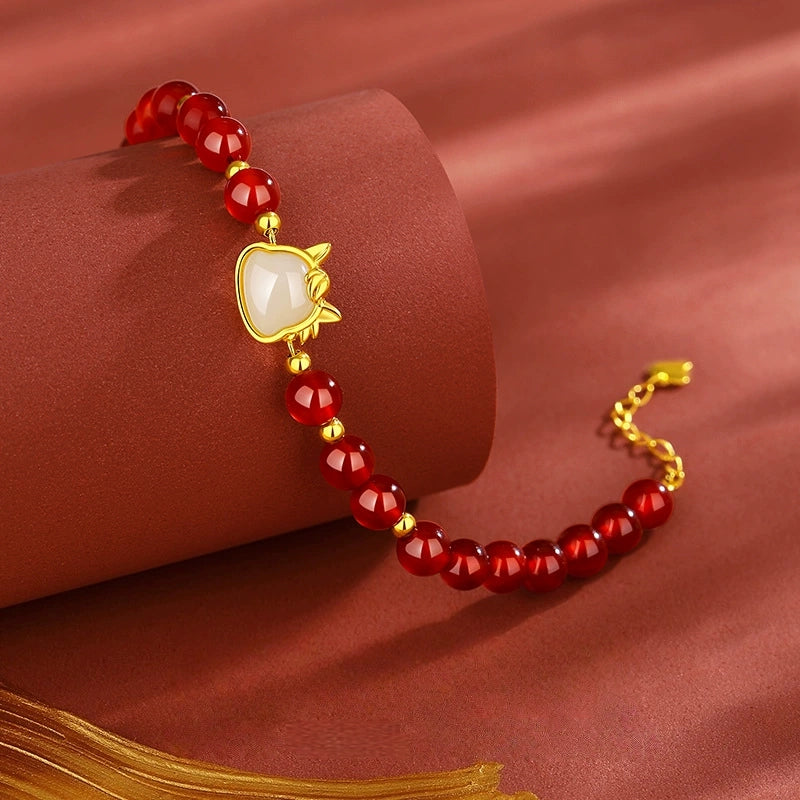 Red agate bracelet with white jade horse detail and S925 gold-tone chain.
