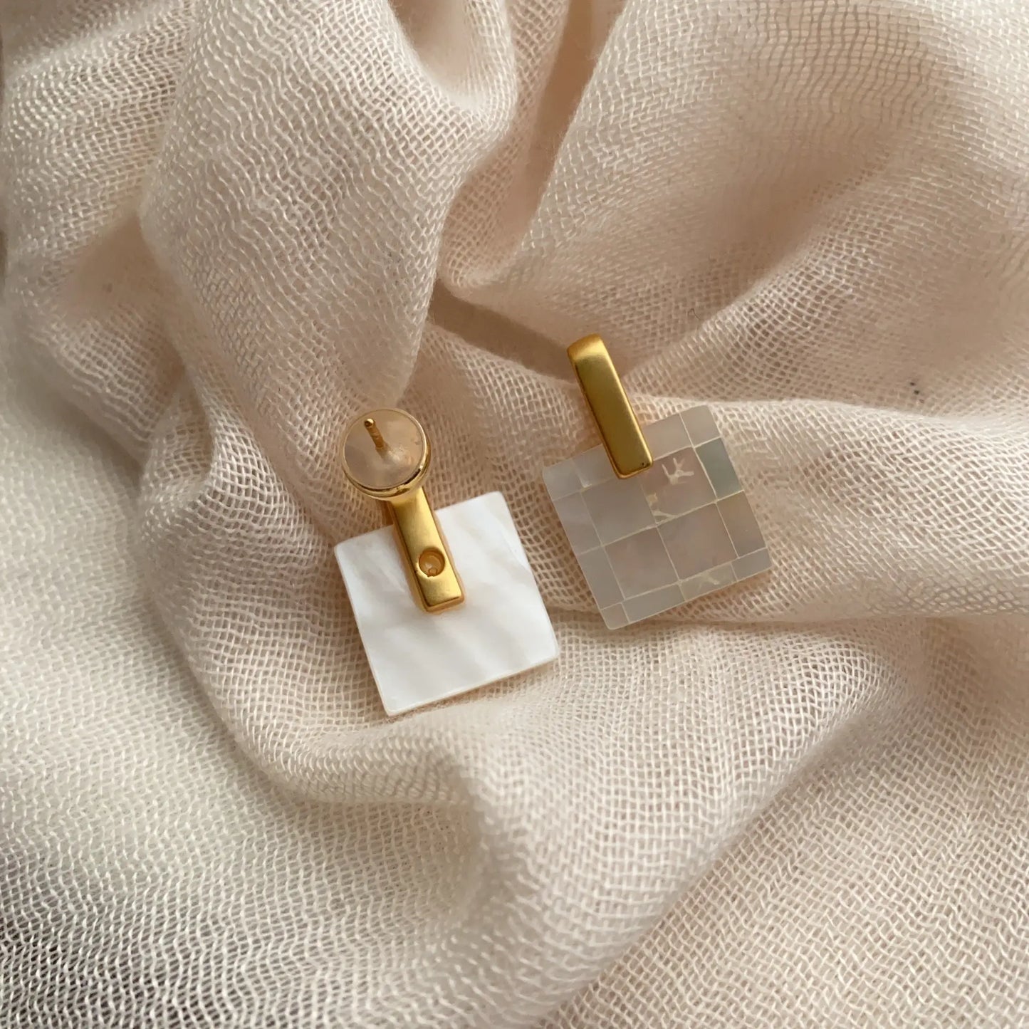 Front and back view of square mother of pearl earrings with gold-tone setting