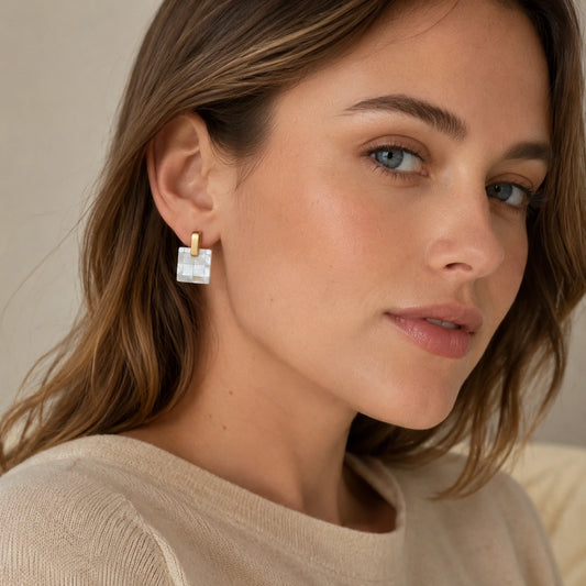 Model wearing square mother of pearl checkerboard earrings in a natural portrait