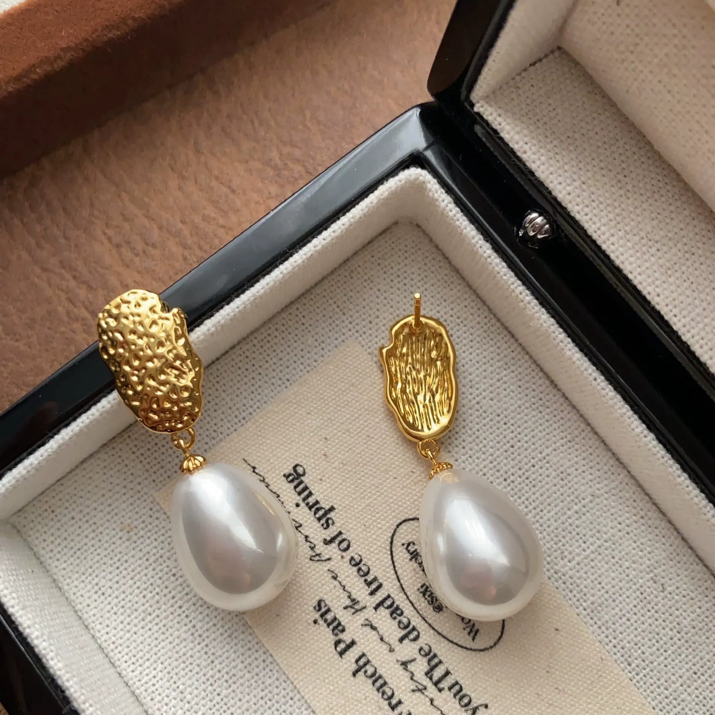 Front and back view of textured gold pearl earrings showing the stud fastening.