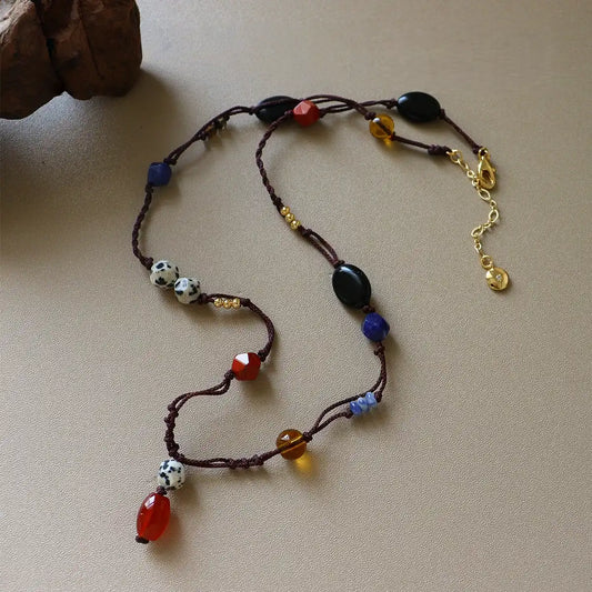 Vintage mixed gemstone rope necklace with dalmatian jasper, red stone, black agate, brass details, and brown cord