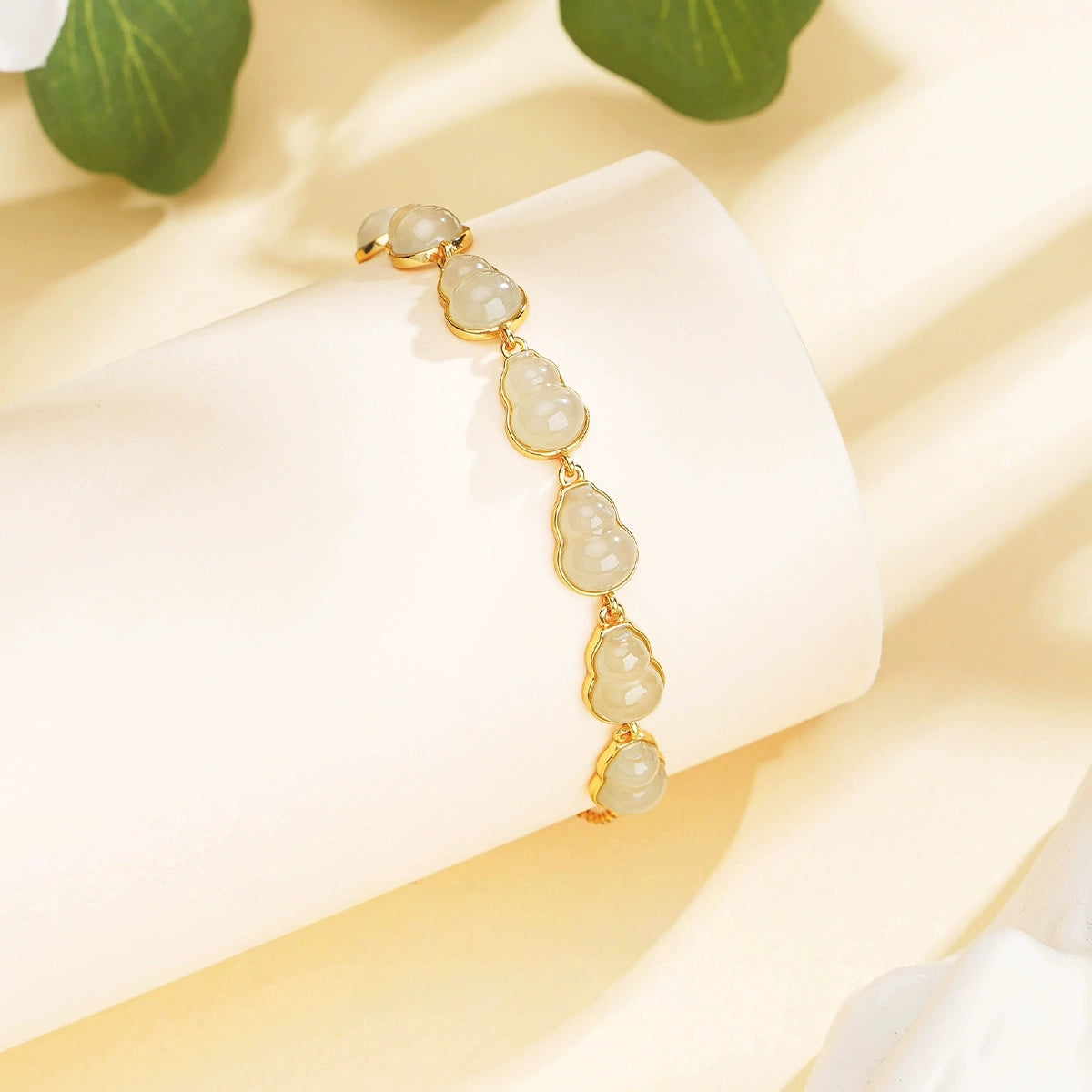 Close-up of white Hetian jade hulu bracelet with delicate gourd-shaped jade details.