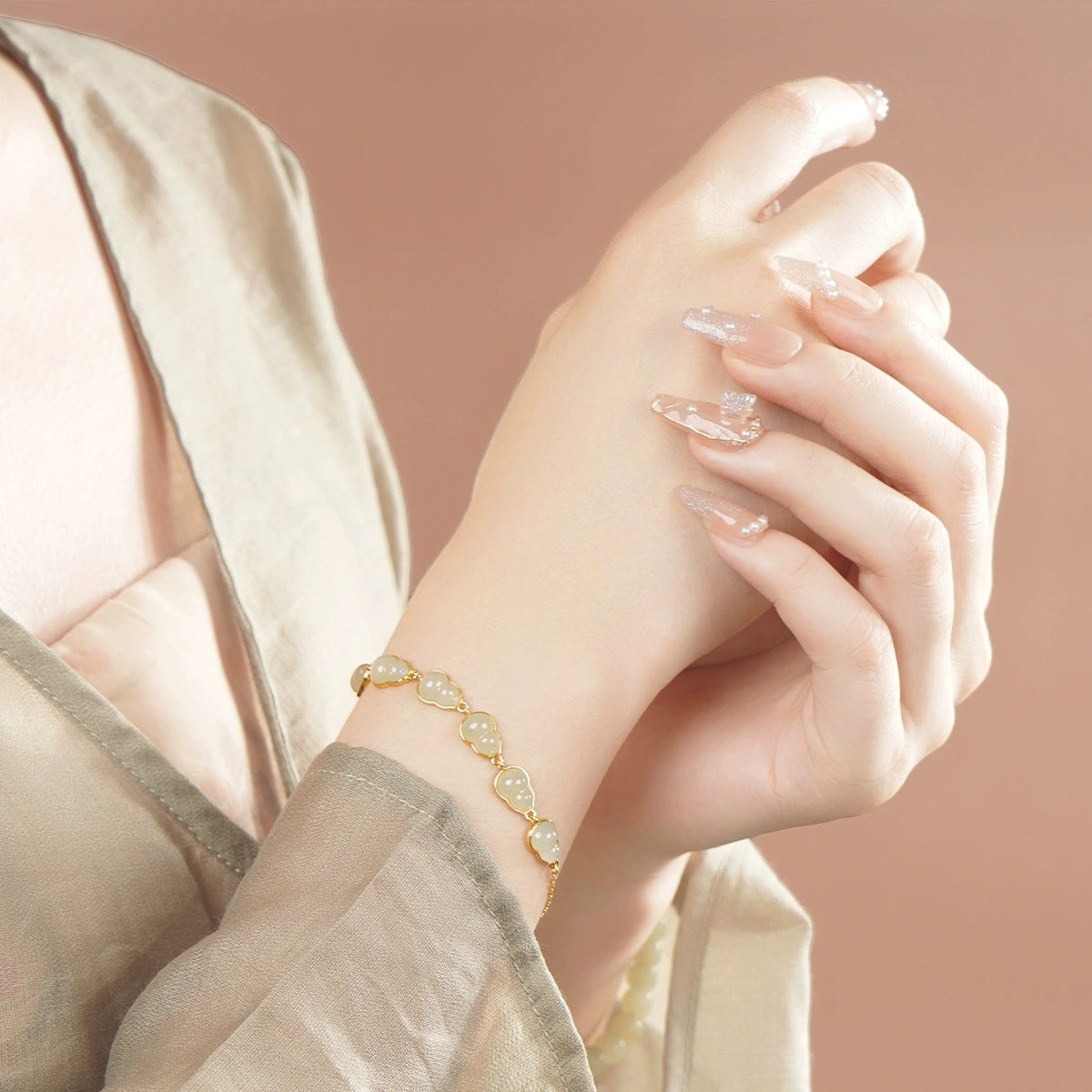 White Hetian jade hulu bracelet worn on wrist with minimalist neutral outfit.